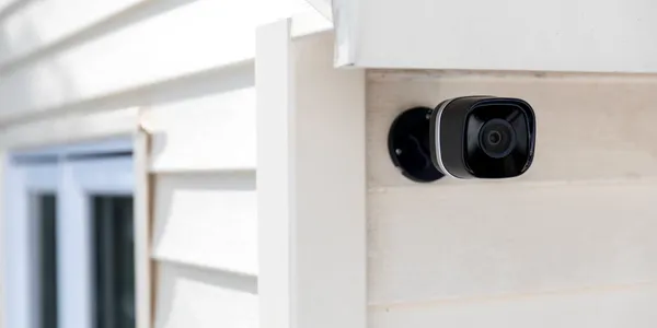 Security system with a camera placed on the side of a home.
